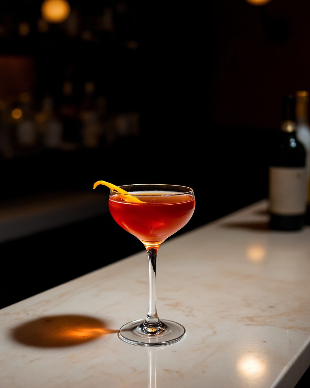 AI-genereret billede: En ravrød cocktail i en coupe med orangezest på en stenbardisk